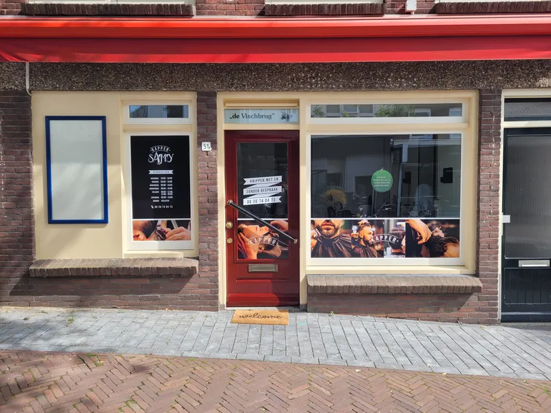 De gevel van Rijnstraat 51 met de rode luifel en de ossenbloedrode deur